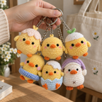 Six handmade crochet chick keychains displayed together in different outfits and colors