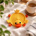 Yellow duck crochet coaster with round body and orange feet