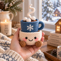 Hot Cocoa crochet winter decor with blue mug, marshmallows, and snowflake detail in a smiling pot