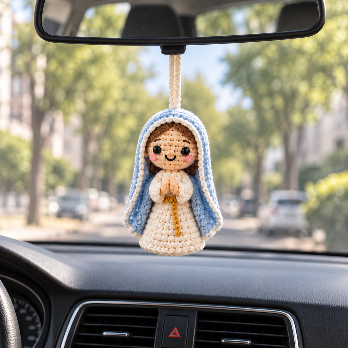 Mother Mary crochet car hanging displayed from a rearview mirror inside a car