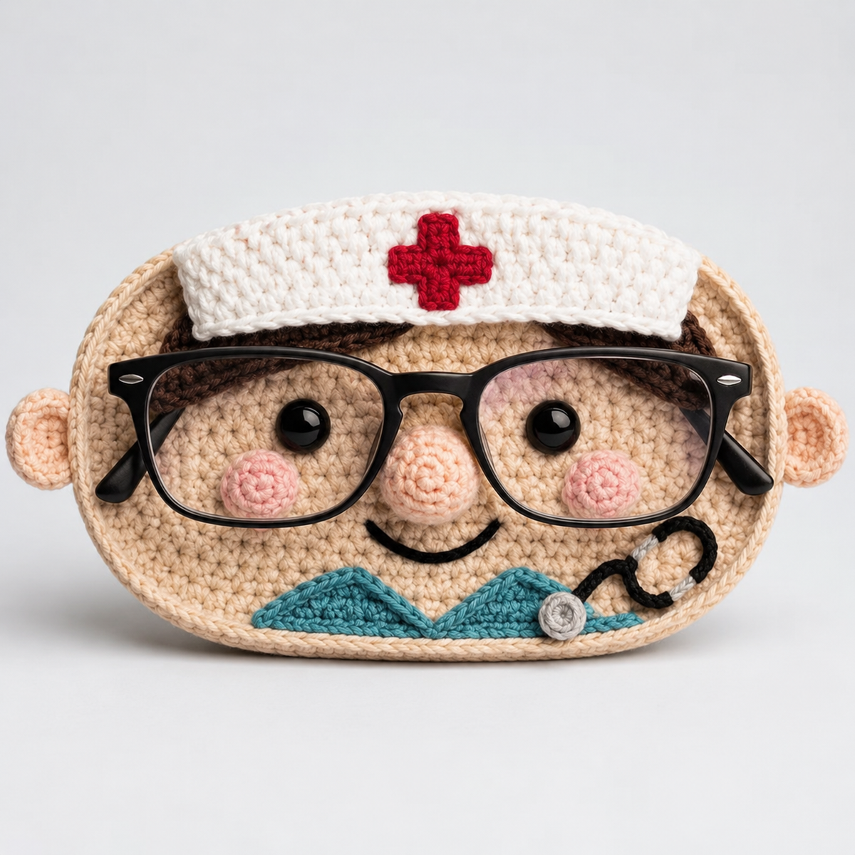 Scrub Nurse crochet glasses holder with white medical cap, red cross, teal scrubs, stethoscope, and black eyeglasses