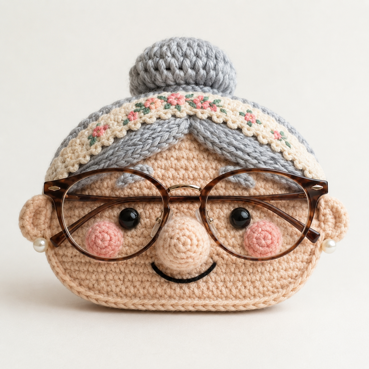 Grandma crochet glasses holder with gray bun, floral headband, rosy cheeks, and brown eyeglasses