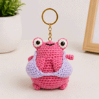 Pink frog crochet keychain with lavender outfit detail and large playful eyes