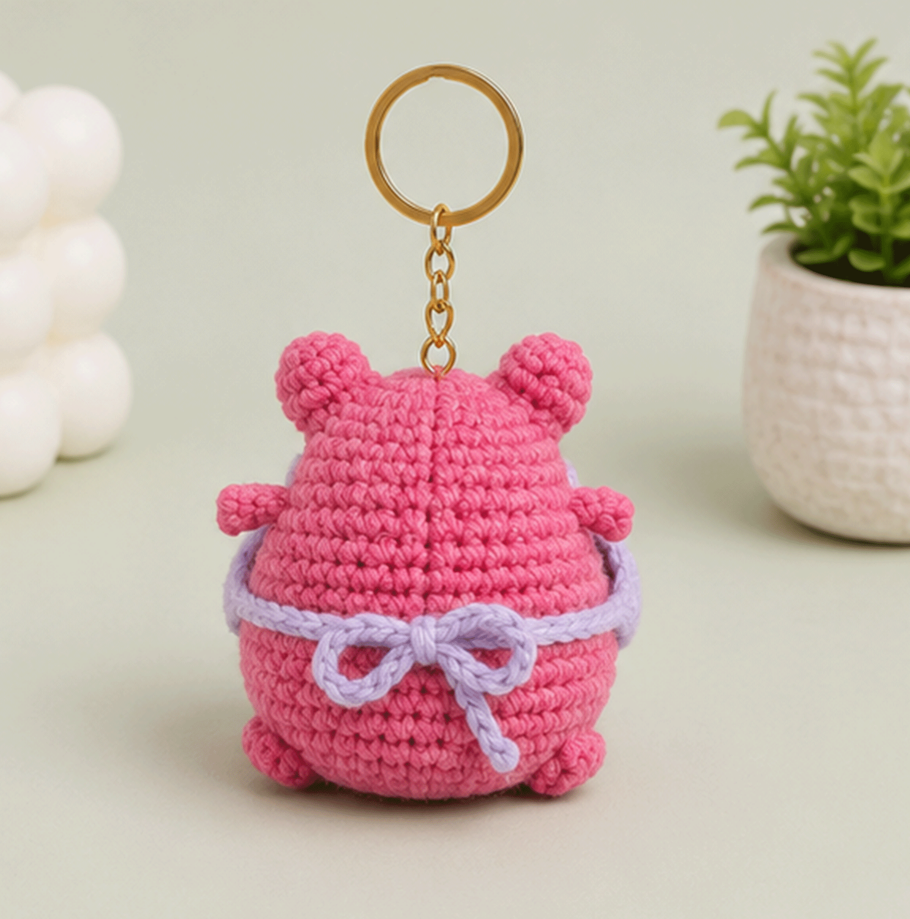Back view of pink frog crochet keychain with lavender bow detail